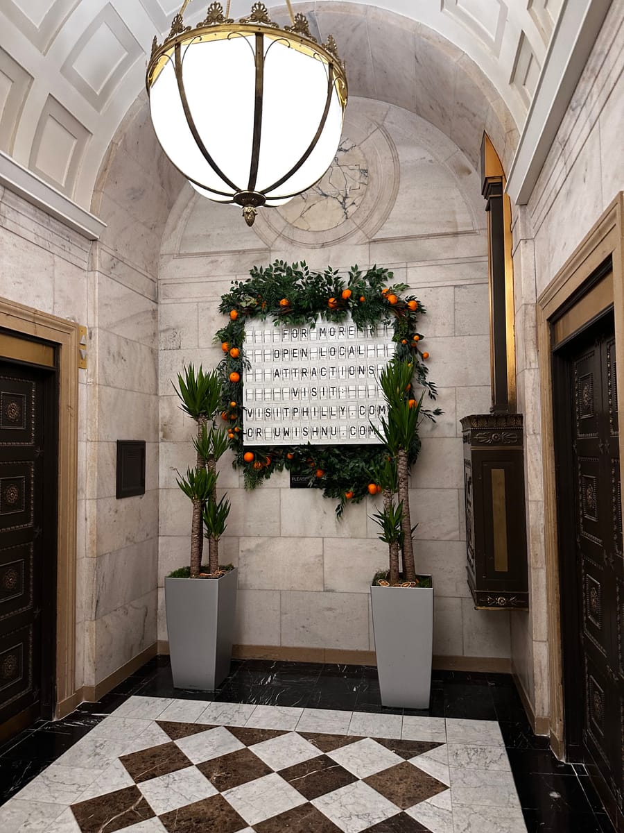 A marble entryway with a checkered floor and a globe lamp