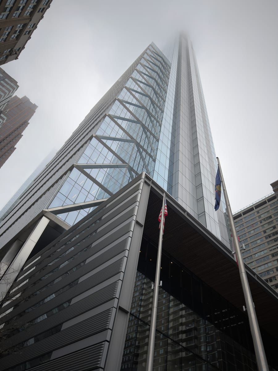 A glass tower disappearing into fog