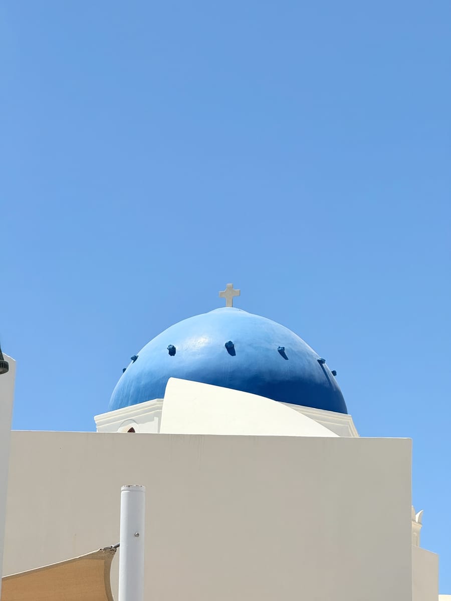 A small blue dome behind a white wall