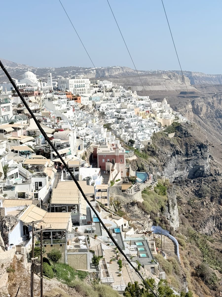 White houses stacked along the caldera cliff